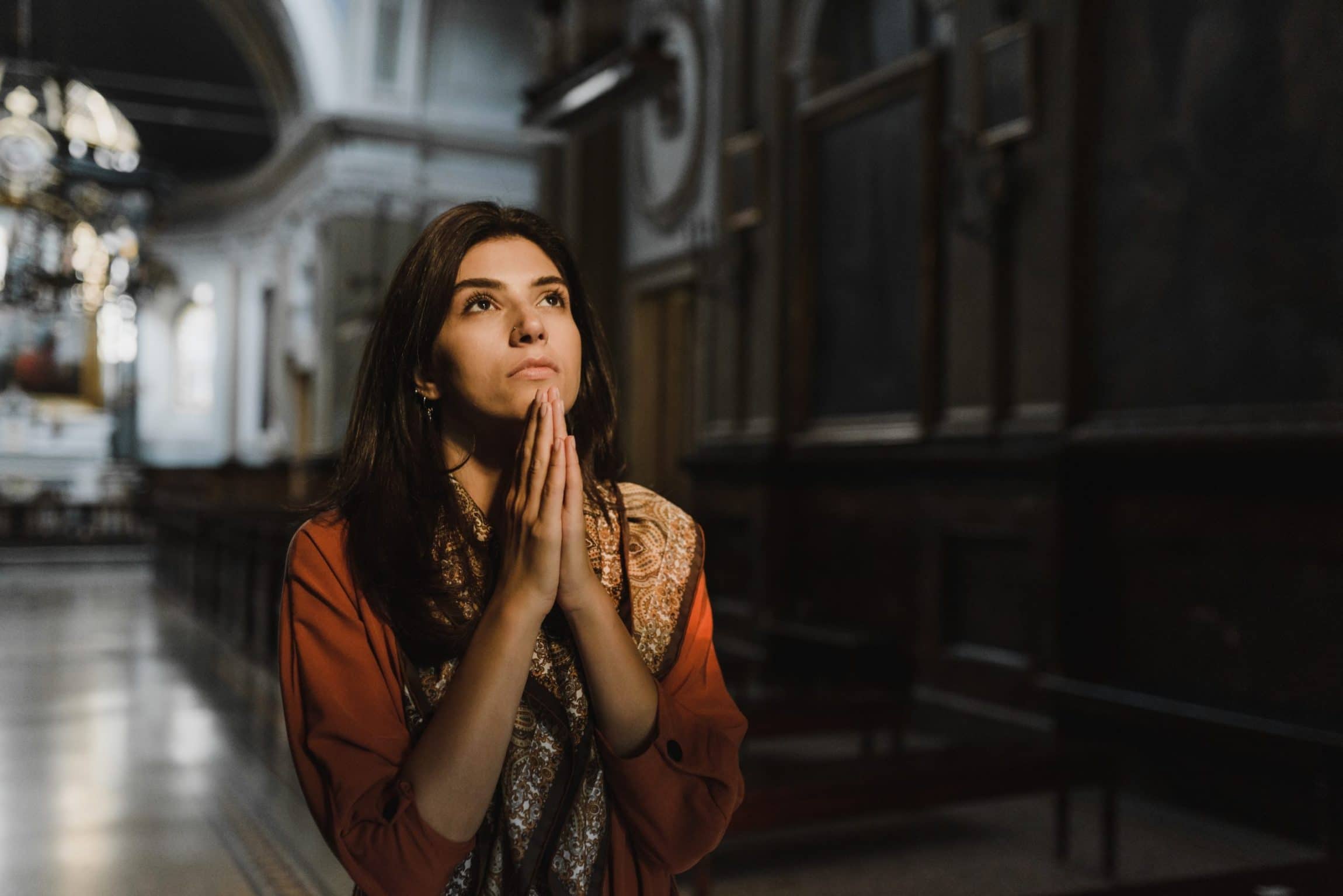 woman kneeling in church to pray