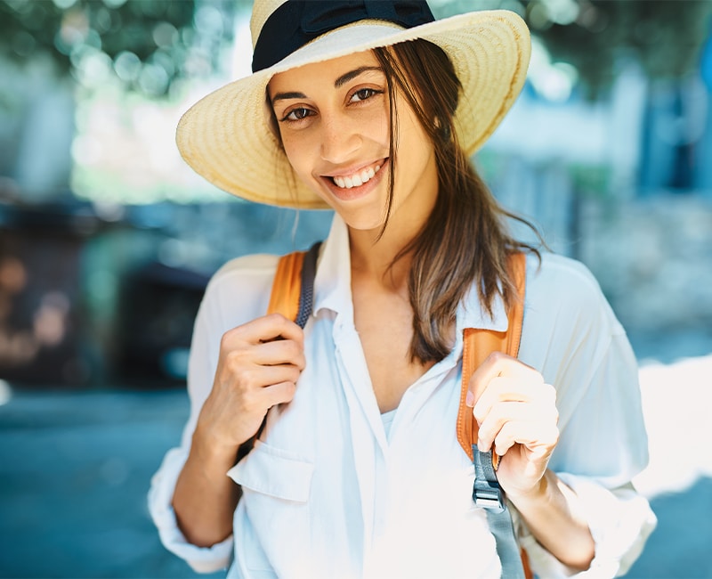 portrait beautiful smiling travel nurse woman tourist in straw hat, white shirt smiling and looking to camera.