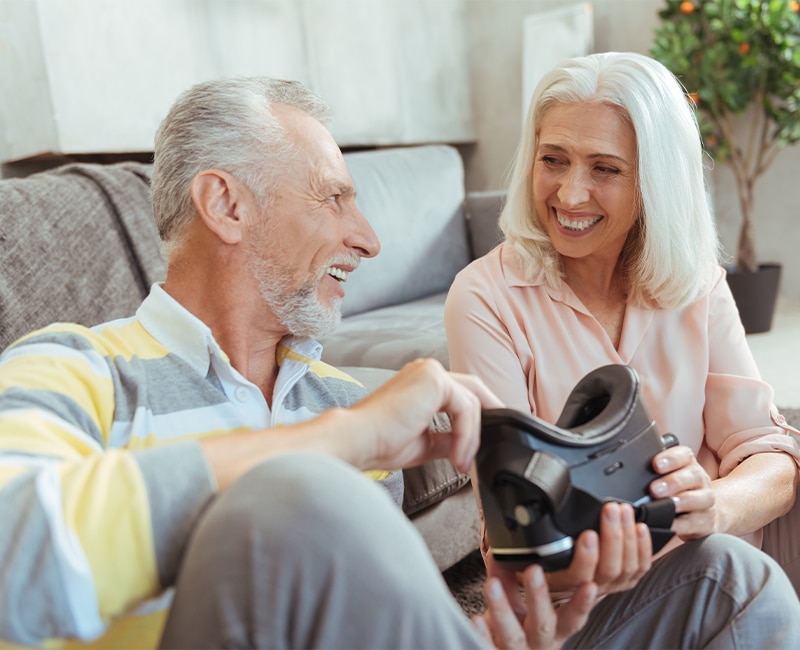 Joyful retired couple testign a new VR device